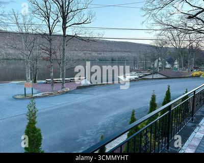 Jenkintown, Pennsylvania, USA - 1. April 2025: Eine ruhige Seeszene mit Bäumen und einer Straße in Pennsylvania, USA. Stockfoto
