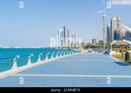 Uferpromenade in Abu Dhabi, VAE, mit modernen Wolkenkratzern entlang der Küste des Persischen Golfs an einem klaren, sonnigen Tag. Stockfoto