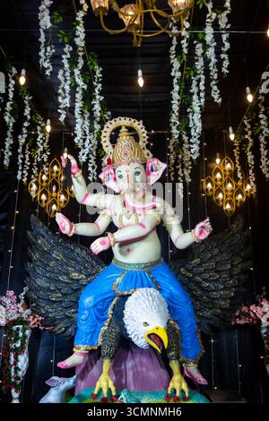 Dekoratives Idol von Lord Ganesha auf Garuda mit festlicher Beleuchtung und Blumendekor Stockfoto