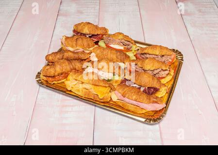 Mini-Blätterteigcroissants gefüllt mit Curry-Hähnchen und Rosinen, bestreut mit gehacktem frischem Schnittlauch und Paprika Stockfoto
