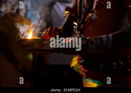 Geweihter, der während des Thaipusam-Festivalrituals Weihrauch hält, wobei Rauch in der Luft aufsteigt Stockfoto