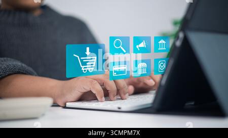 Person, die auf einem Tablet mit E-Commerce-Symbolen, digitalem Warenkorb, Online-Shop, Marketing, Kreditkartenzahlung, fintech und Unternehmenstechnologie für Stockfoto