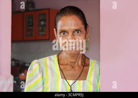 Indische reife Frau lächelt. Porträt einer glücklichen älteren Nordost-Goa-Indianerin, die vom Haus aus in die Kamera schaut. Reisefoto, Editorial, November 16,20 Stockfoto