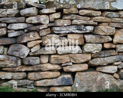 Gestapelte Steine einer rustikalen Trockensteinmauer Nahaufnahme - Eine detaillierte Nahaufnahme einer traditionellen Trockensteinmauer, die die Textur, Farben und natürlichen Klaps zeigt Stockfoto