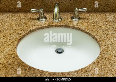Waschbecken mit Marmorplatte und eingebautem Wasserhahn. Stockfoto