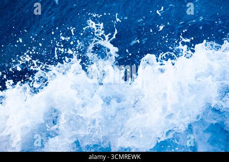 Rollende Wellen im Ozean. Blauer Wasserhintergrund mit weißem Schaum. Rauschendes Wasser im offenen Meer. Stockfoto