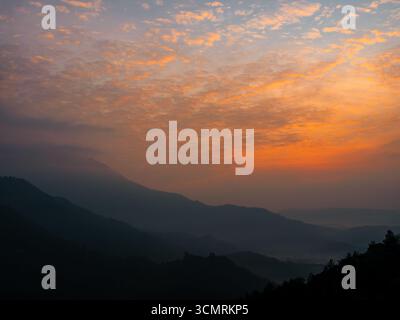 Wunderschöner orangefarbener Himmel und Berge vor Sonnenaufgang in Indien Stockfoto