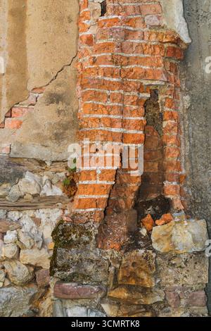 Detaillierte Ansicht einer sich verschlechternden Mauern aus Ziegeln und Stein, die Risse, Erosion und Witterung zeigen und rustikalen architektonischen Verfall und historische Geschichte hervorheben Stockfoto