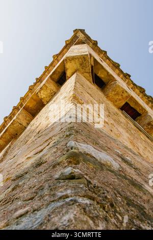 Aus nächster Nähe sehen Sie einen historischen Steinfestungsturm mit strukturierten mittelalterlichen Mauern. Das Foto betont Architektur und Perspektive gegenüber einer Clea Stockfoto