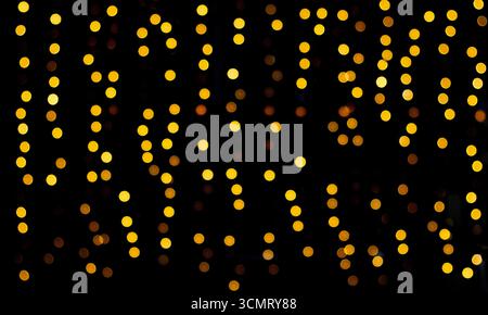Goldene Bokeh-Lichter auf dunklem Hintergrund schaffen eine warme, glühende Atmosphäre Stockfoto