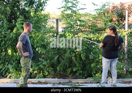 Mann und Frau interagieren, Gartendienste arbeiten Stockfoto
