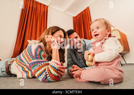 Ein wunderbarer Familienmoment, in dem Eltern spielerische Interaktionen mit ihrem Baby genießen und freudige Erinnerungen voller Lachen und Liebe in A schaffen Stockfoto