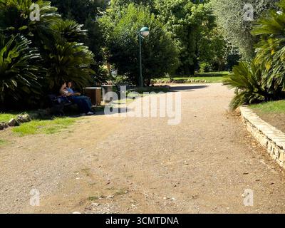 Sonniger Nachmittag Spaziergang durch einen friedlichen Park voller üppiger Vegetation und entspannender Momente in der Nähe des Weges Stockfoto