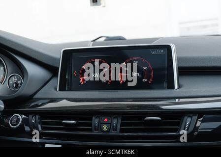 Nahaufnahme des Infotainment-Systems im Fahrzeug. Leistungsmessgeräte für sportliches Fahren, die Leistung in kW und Drehmoment in NM anzeigen Stockfoto