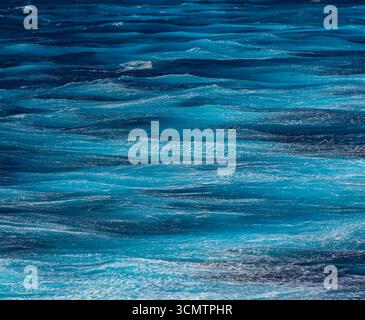Blick auf das Meer aus der Luft. Hintergrundaufnahme der klaren Meerwasseroberfläche. Blaues Meerwasser in Ruhe. Meeresstruktur. Hintergrund blaue Wellen des Ozeans Stockfoto