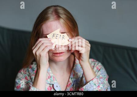 Frau, die Papier hält mit Wort 'Angst', Begriff von Angst und geistiger Gesundheit. Stockfoto