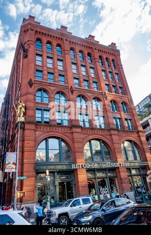 New York, NY - USA - 14. September 2025 das Puck Building in NYC zeigt eine vergoldete Puck-Statue auf der roter Backsteinfassade im romanischen Revival mit German Rund Stockfoto