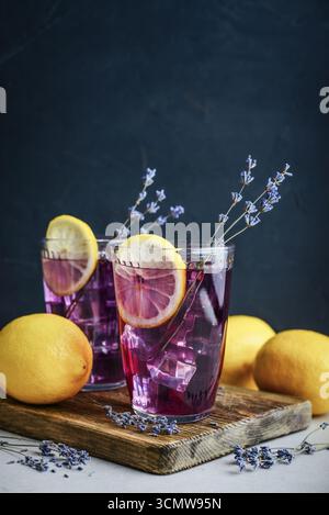 Sommerlimonade mit Lavendel, Zitronensaft und Heidelbeeren in zwei Gläsern auf dunklem Hintergrund Stockfoto