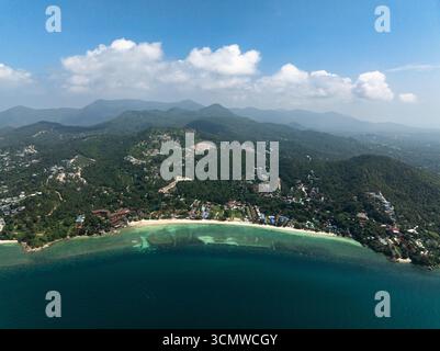 Blick aus der Vogelperspektive auf lebendige türkisfarbene Buchten und üppiges tropisches Grün in einer ruhigen Küstenlandschaft. Ko Pha Ngan, Thailand. Stockfoto