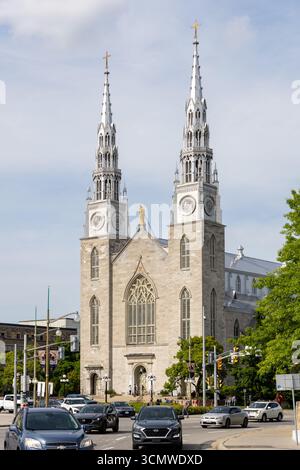 Ottawa, Kanada - 13. Juni 2025: Basilika Notre-Dame in der Innenstadt, historische katholische Kirche und Wahrzeichen in der Hauptstadt mit Verkehr auf t Stockfoto