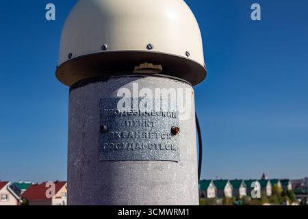 Eine Nahaufnahme eines geodätischen Vermessungspunktes mit einer metallischen Kuppel oben und einem Schild mit der Aufschrift Geodätischer Punkt, der vom Staat geschützt ist, im Lesnaya Pol Stockfoto