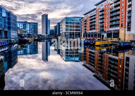 Leeds Dock mit Kanalbooten und modernen Gebäuden, die sich im stillen Wasser spiegeln Stockfoto