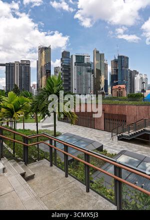Kuala Lumpur, Malaysia - 1. März 2025: TRX City Park, moderner Stadtpark mit Palmen, Treppen und zeitgenössischer Architektur vor einer Skyline aus Wolkenkratzern, darunter Tribeca und Capri Stockfoto