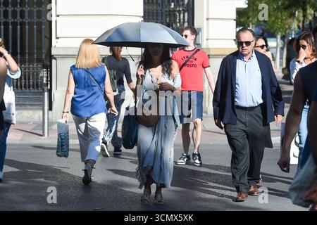 Madrid, Spanien. September 2025. Eine Frau, die einen Schirm hält, läuft in einer Straße in Madrid, Spanien, 17. September 2025. Die spanische staatliche Meteorologische Agentur (AEMET) sagte, dass es bis September in den meisten Gebieten heißer sein wird als sonst, da die Temperaturen in einigen südlichen Gebieten voraussichtlich über 38 Grad Celsius liegen werden. Gustavo Valiente/Xinhua/Alamy Live News Stockfoto