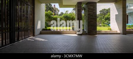 Geräumiger, moderner Eingang mit üppigem Grün, perfekt für luxuriöses Wohnen und nahtlosen Innen- und Außenfluss. Stockfoto