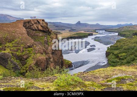 Vier Leute auf Steilhang, die über das Flusstal bei Thorsmork, Island, blicken Stockfoto