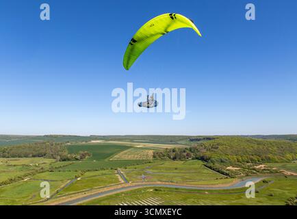 Gleitschirmflieger fliegen über das malerische Cuckmere Valley und South Downs in High and Over, nahe Alfriston, East Sussex, Großbritannien Stockfoto