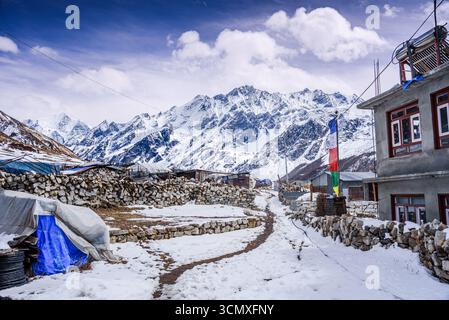 Schneebedeckter Pfad durch Steinmauern und Lodges im Dorf Kyanjin Gompa, Nepal Stockfoto