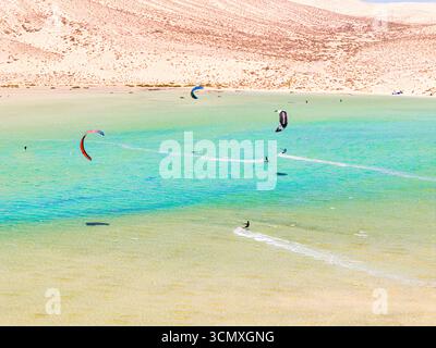 Aus der Vogelperspektive auf Kitesurfer, umgeben von vulkanischen Klippen, Sotavento Beach, Jandia, Fuerteventura, Kanarischen Inseln, Spanien Stockfoto
