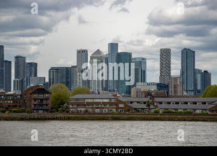 Ein Bild der modernen Apartments und Büros auf der Isle of Dogs und Canary Wharf, die an einem bewölkten Tag über der Themse gesehen werden. Stockfoto
