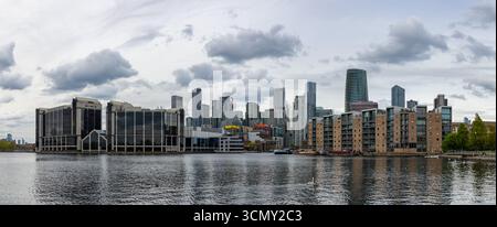 Ein Bild der modernen Apartments und Büros auf der Isle of Dogs und der Canary Wharf aus Sicht vom Millwall Outer Dock an einem bewölkten Tag. Stockfoto