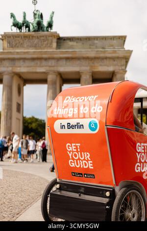 Berlin, Deutschland - 1. September 2025: Eine Fahrrad-Rikscha steht vor dem Brandenburger Tor und lädt Touristen ein, die Aktivitäten in Berlin zu entdecken. C Stockfoto
