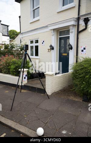 Ein Laserscanner auf einem Stativ, der während einer Vermessung für eine Planungsanwendung in einem Wohnhaus/Gebäude verwendet wird. Ziele sind an der Wand. UK. (140) Stockfoto
