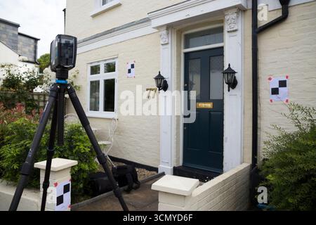 Ein Laserscanner auf einem Stativ, der während einer Vermessung für eine Planungsanwendung in einem Wohnhaus/Gebäude verwendet wird. Ziele sind an der Wand. UK. (140) Stockfoto
