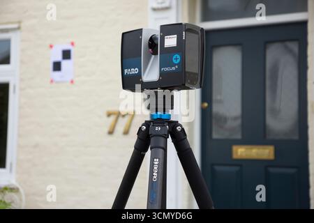 Ein Laserscanner auf einem Stativ, der während einer Vermessung für eine Planungsanwendung in einem Wohnhaus/Gebäude verwendet wird. Ziele sind an der Wand. UK. (140) Stockfoto