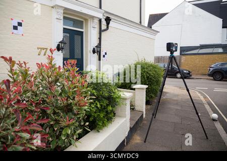 Ein Laserscanner auf einem Stativ, der während einer Vermessung für eine Planungsanwendung in einem Wohnhaus/Gebäude verwendet wird. Ziele sind an der Wand. UK. (140) Stockfoto