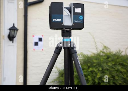Ein Laserscanner auf einem Stativ, der während einer Vermessung für eine Planungsanwendung in einem Wohnhaus/Gebäude verwendet wird. Ziele sind an der Wand. UK. (140) Stockfoto