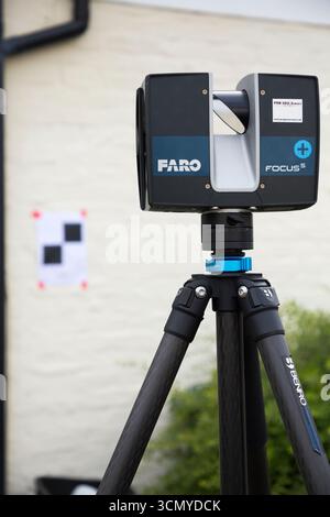 Ein Laserscanner auf einem Stativ, der während einer Vermessung für eine Planungsanwendung in einem Wohnhaus/Gebäude verwendet wird. Ziele sind an der Wand. UK. (140) Stockfoto