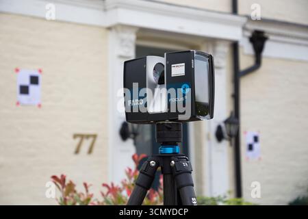 Ein Laserscanner auf einem Stativ, der während einer Vermessung für eine Planungsanwendung in einem Wohnhaus/Gebäude verwendet wird. Ziele sind an der Wand. UK. (140) Stockfoto