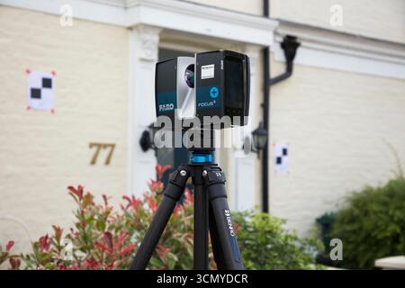 Ein Laserscanner auf einem Stativ, der während einer Vermessung für eine Planungsanwendung in einem Wohnhaus/Gebäude verwendet wird. Ziele sind an der Wand. UK. (140) Stockfoto