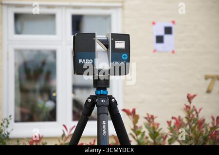 Ein Laserscanner auf einem Stativ, der während einer Vermessung für eine Planungsanwendung in einem Wohnhaus/Gebäude verwendet wird. Ziele sind an der Wand. UK. (140) Stockfoto