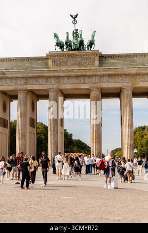 Berlin, Deutschland - 1. September 2025: Menschenmassen erkunden das berühmte Brandenburger Tor in Berlin an einem klaren, sonnigen Tag. Familien, Touristen und freitag Stockfoto