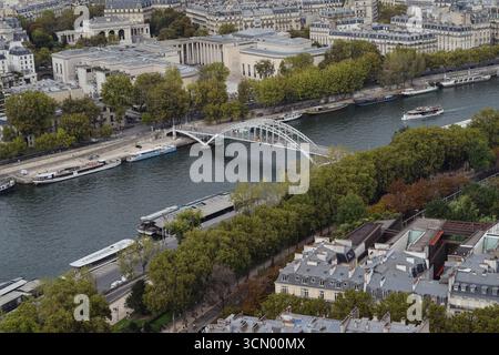 Panoramablick auf die Brücke Passerelle Debilly über die seine in Paris, umgeben von historischen Gebäuden und üppigen Bäumen. Stockfoto