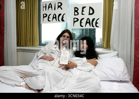 John Lennon und Yoko Ono sehen sich wie Michael Evans und Yu Tian an an, um Peace Eine Chance auf eine Wiederaufnahme ihres Bed-in zu geben, bevor die Texte zum ersten Mal in Bonhams, Montreal, versteigert werden - 24. Oktober 2005 Stockfoto