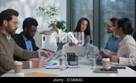 Multikulturelles Geschäftsteam spricht über kaukasische Führungskraft mit Diagrammdiagramm Afroamerikaner Indianer Männer Frauen zusammen Planer Stockfoto