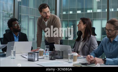 Multiethnische Unternehmensgruppe multiethnische Frauen Männer Geschäftsleute Bürotreffen Briefing Kaukasischer Führer spricht über Planung Afroamerikaner Stockfoto